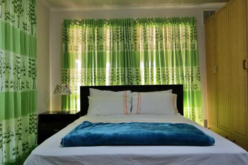 a bedroom with a large bed with green curtains at ParkViewAtMontagueFarm in Mawson Lakes
