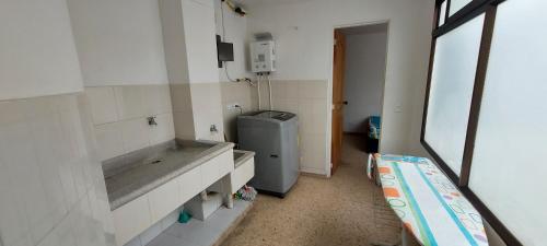 a small bathroom with a sink and a refrigerator at Apartamento Sector Colores - Estadio in Medellín