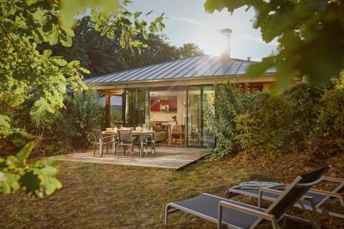 a house with a deck with a table and chairs at Center Parcs Les Bois Francs in Verneuil d’Avre et d’Iton