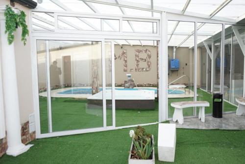 een kamer met een zwembad en een patio met groen gras bij Apart M.B in Pigüé