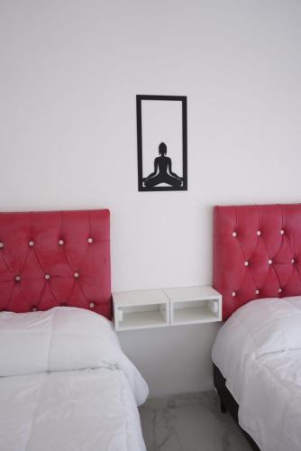 a bedroom with two beds and a red headboard at Apart M.B in Pigüé