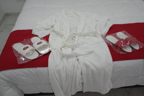 Una cama con ropa blanca y zapatos. en Apart M.B en 