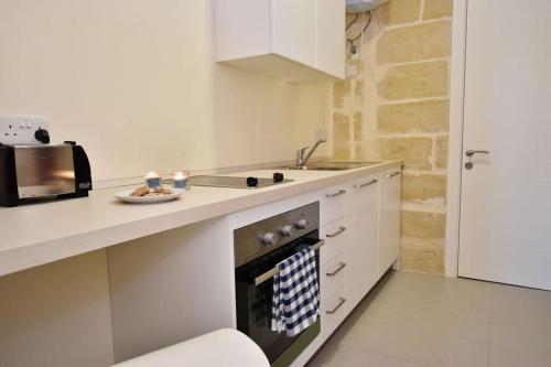 瓦莱塔Lucky Star 402 by Vallettastay的带水槽和炉灶的厨房 顶部烤箱