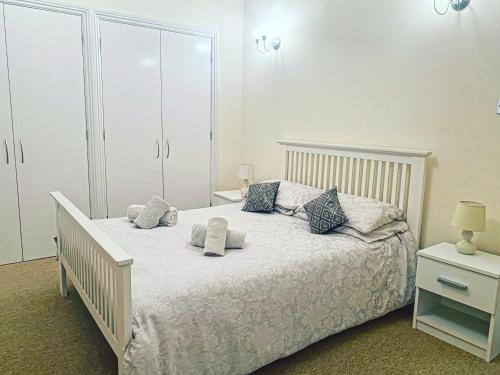 sypialnia z białym łóżkiem z poduszkami w obiekcie LUXURY 2 BEDS APARTMENT BY THE SEA w Bournemouth