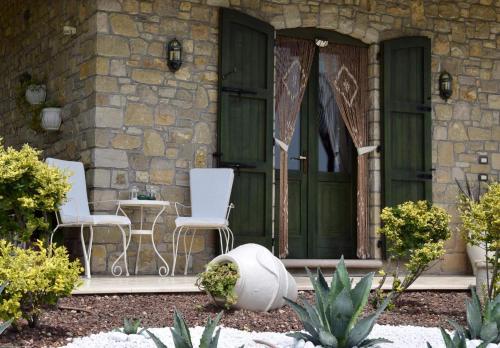 a house with two white chairs and a green door at CHALET VELA Natura e Relax in Gavardo