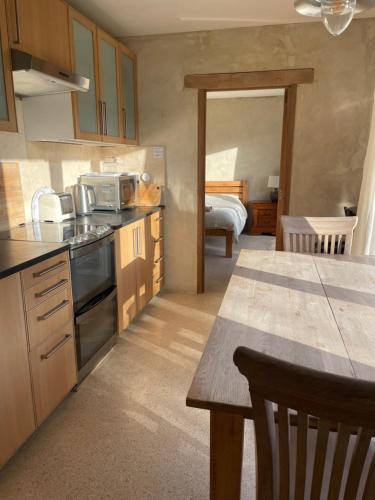 a kitchen with a sink and a table in a room at Shortlake Cottage in Osmington