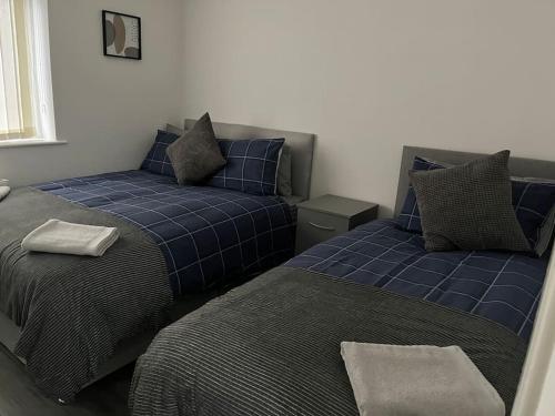 dwa łóżka siedzące obok siebie w sypialni w obiekcie Woolfall House w mieście Roby