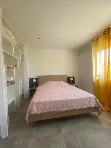 a bedroom with a large bed with a pink blanket at La Villa Day **** in Les Cocos