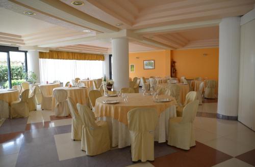a banquet hall with white tables and chairs at Atlantis Palace Hotel in Mascali