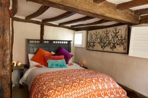 a bedroom with a large bed with colorful pillows at Samsara in West Peckham