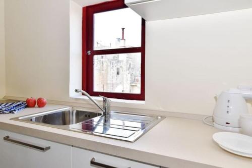 a kitchen with a sink and a window at Vallettastay- Lucky Star Penthouse 501 in Valletta