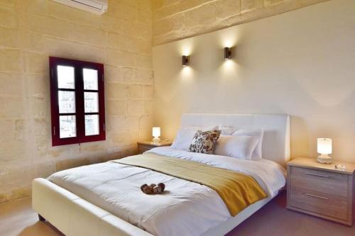 a bedroom with a large bed with a teddy bear on it at Vallettastay- Lucky Star Penthouse 501 in Valletta