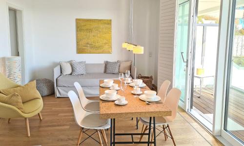 - une salle à manger avec une table, des chaises et un canapé dans l'établissement Am Hohen Ufer Whg 5, à Grömitz