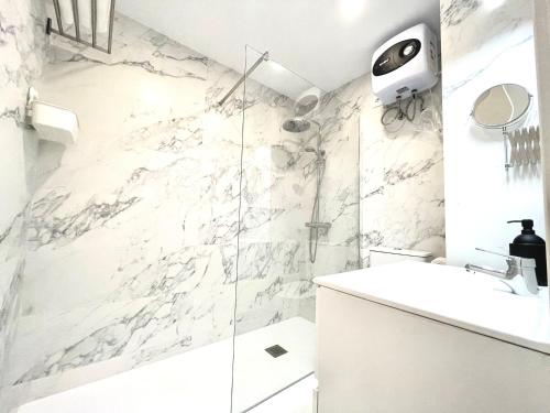 um banheiro branco com pia e chuveiro em Timeless clock Apartment em San Bartolomé