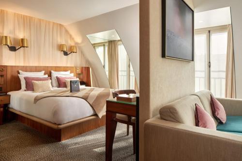 a bedroom with a bed and a couch and a mirror at Maison Albar - Le Pont-Neuf in Paris
