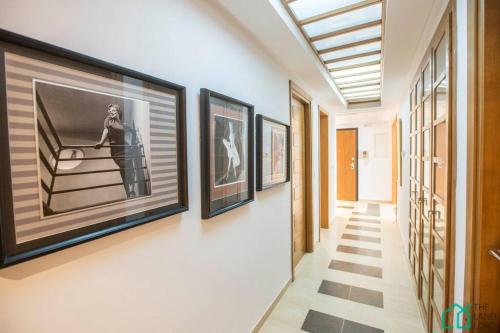 a hallway with framed pictures on the wall at Le Premium Central luxueux et très confortable in Sidi Daoud