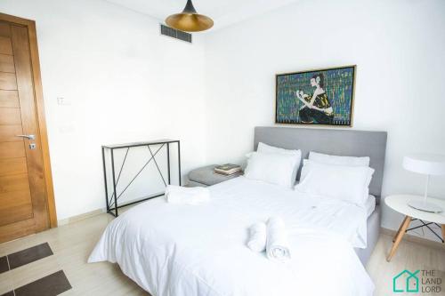 a bedroom with a large white bed with white pillows at Le Premium Central luxueux et très confortable in Sidi Daoud