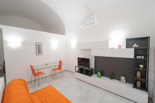 uma sala de estar com um sofá laranja e uma mesa em Vico Amico by Dimorra em Nápoles