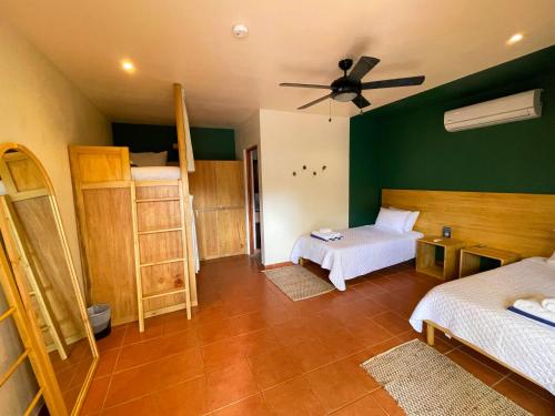 a bedroom with two beds and a ceiling fan at ONDA - Playa Grande - Adults Only in Playa Grande