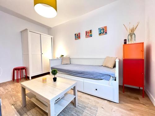 une petite chambre avec un lit et une table dans l'établissement Le Michigan, studio à 5 min du centre-ville, à Poitiers