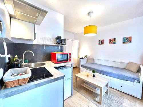 une petite cuisine avec un évier et un canapé dans l'établissement Le Michigan, studio à 5 min du centre-ville, à Poitiers