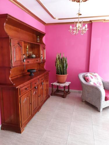 a bathroom with pink walls and a sink and a chair at Casa Rural Fayna in Granadilla de Abona