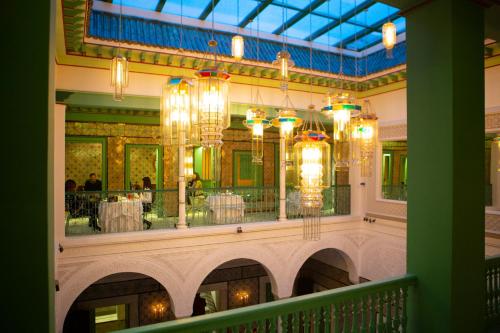 un restaurant avec des lustres et des tables dans un bâtiment dans l'établissement Dar Dorra, à Tunis