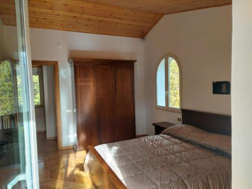 a bedroom with a bed and two windows in it at Villa Angela 2 Santa Maria del Molise in Santa Maria del Molise