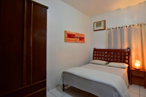 a small bedroom with a bed and a window at Estalagem 11 Suites in Arraial do Cabo