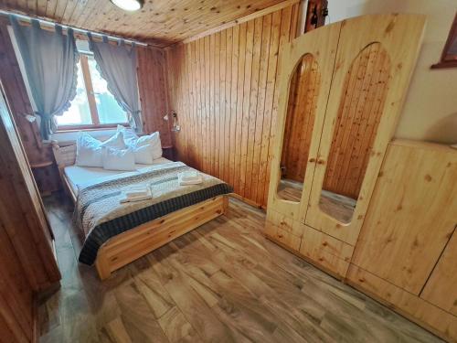sypialnia z łóżkiem i drewnianą podłogą w obiekcie Balla nyaraló w Siófoku