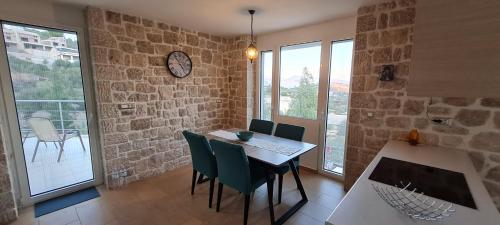 a dining room with a table and chairs and a clock at Πέτρα, Ελιά και Λεβάντα in Tolo