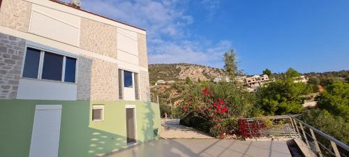 a view of a building with a mountain in the background at Πέτρα, Ελιά και Λεβάντα in Tolo