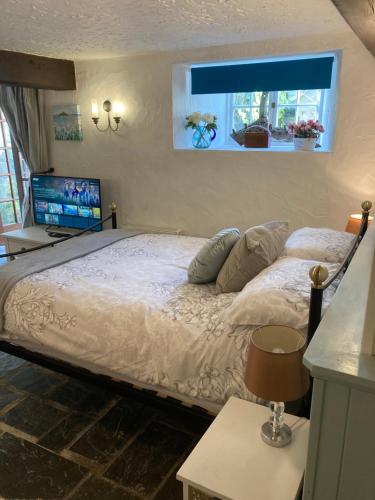 a bedroom with a large bed with a window at Mill Retreat at Bissick Old Mill in Truro