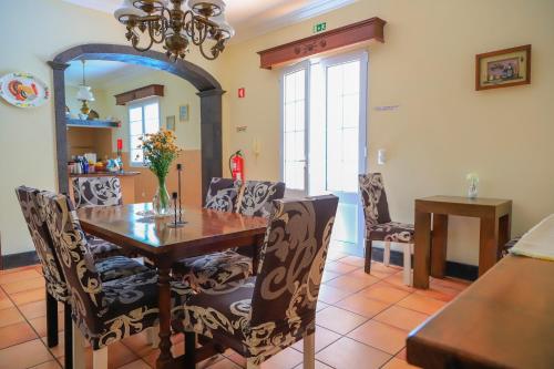 a dining room with a wooden table and chairs at Bella Italia Populo Guest House in Ponta Delgada