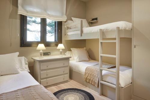 ein Schlafzimmer mit zwei Etagenbetten und einem Fenster in der Unterkunft Tanau by FeelFree Rentals in Naut Aran