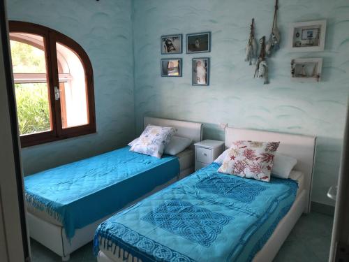 una camera con due letti e una finestra di Appartamento in villa Porto Istana a Olbia