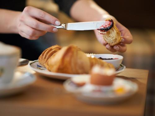 a person is eating a croissant on a table at Eurener Hof in Trier