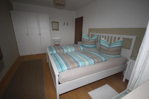 a bedroom with a white bed with pillows at Ferienwohnung Bothe in Zandt