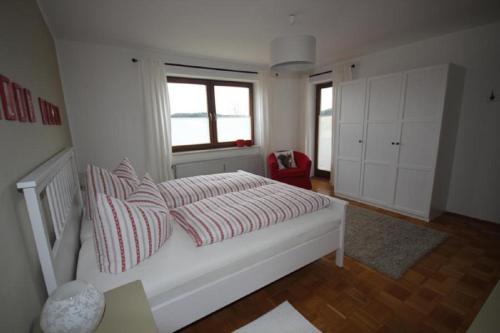 a bedroom with a bed with red and white striped pillows at Ferienwohnung Bothe in Zandt