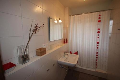 a bathroom with a sink and a white shower curtain at Ferienwohnung Bothe in Zandt