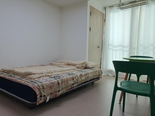 a bedroom with a bed and a table and a chair at Cozy House in Daegu