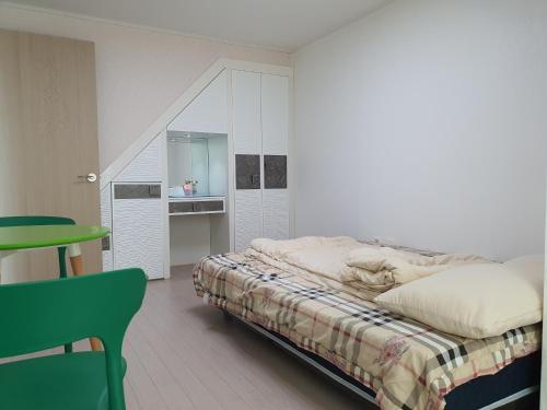 a bedroom with a bed and a table and a chair at Cozy House in Daegu