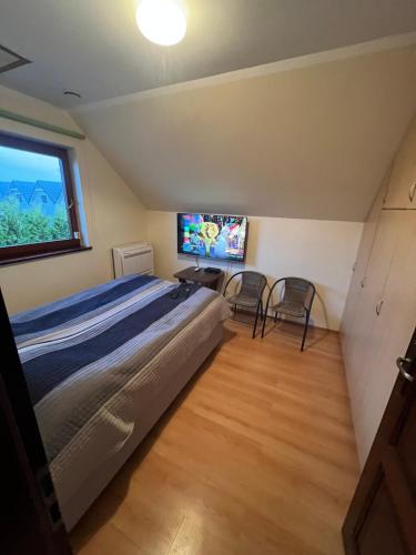 sypialnia z łóżkiem i telewizorem z płaskim ekranem w obiekcie kormoran-sarbinowo w Sarbinowie