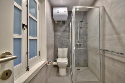 uma casa de banho com um WC e um chuveiro em VALLETTASTAY - ORANGERIE TWO BEDROOM APARTMENT 201 em Valeta