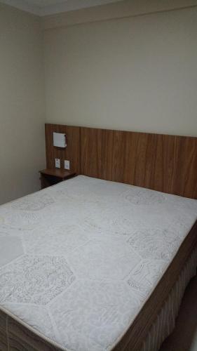 1 dormitorio con 1 cama grande y cabecero de madera en Piazza Caldas com acesso gratuito Acqua Park Diroma, en Caldas Novas