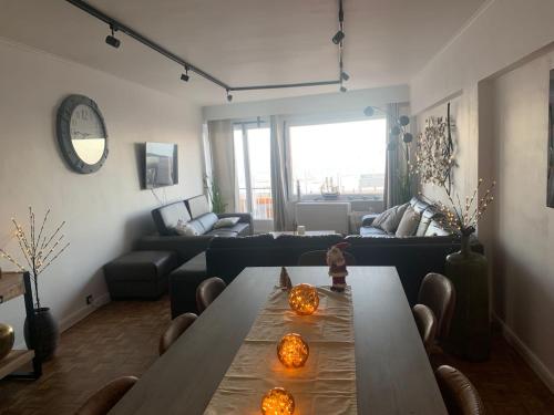 ein Wohnzimmer mit einem Tisch und einem Sofa in der Unterkunft Madame Mouette in Blankenberge