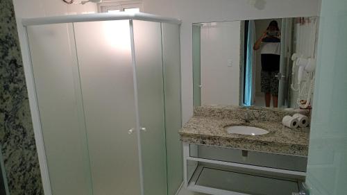 La salle de bains est pourvue d'un lavabo et d'un miroir. dans l'établissement Piazza Caldas com acesso gratuito Acqua Park Diroma, à Caldas Novas