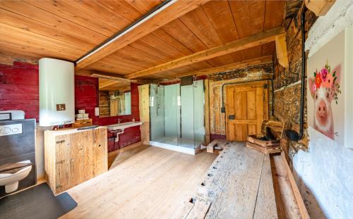 a bathroom with a glass shower and wooden walls at Großmutters Haus in Westendorf