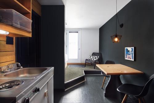 a kitchen with a sink and a wooden table at Beatnik Hotel in Bromont