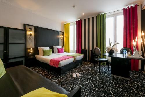 パリにあるホテル ペイリス オペラのベッドとデスクが備わるホテルルームです。